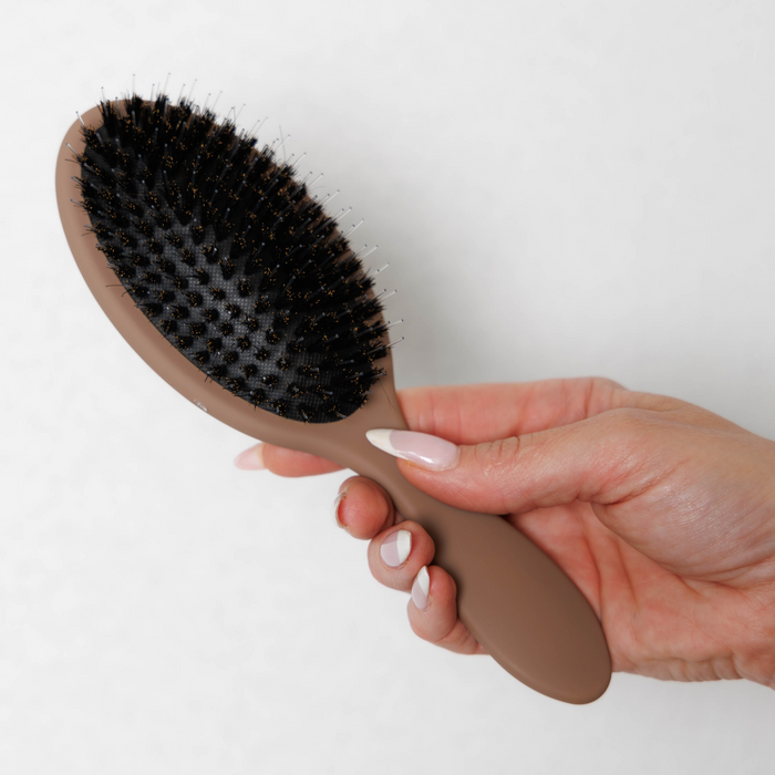 Bristle side of the Mane Baby Original Boar Bristle Brush held in hand, showing the cushioned pad
