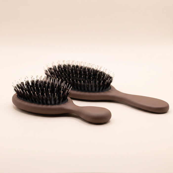 Mane Baby Brush Duo shown side on, revealing the cushioned pad depth and bristle height of both brushes