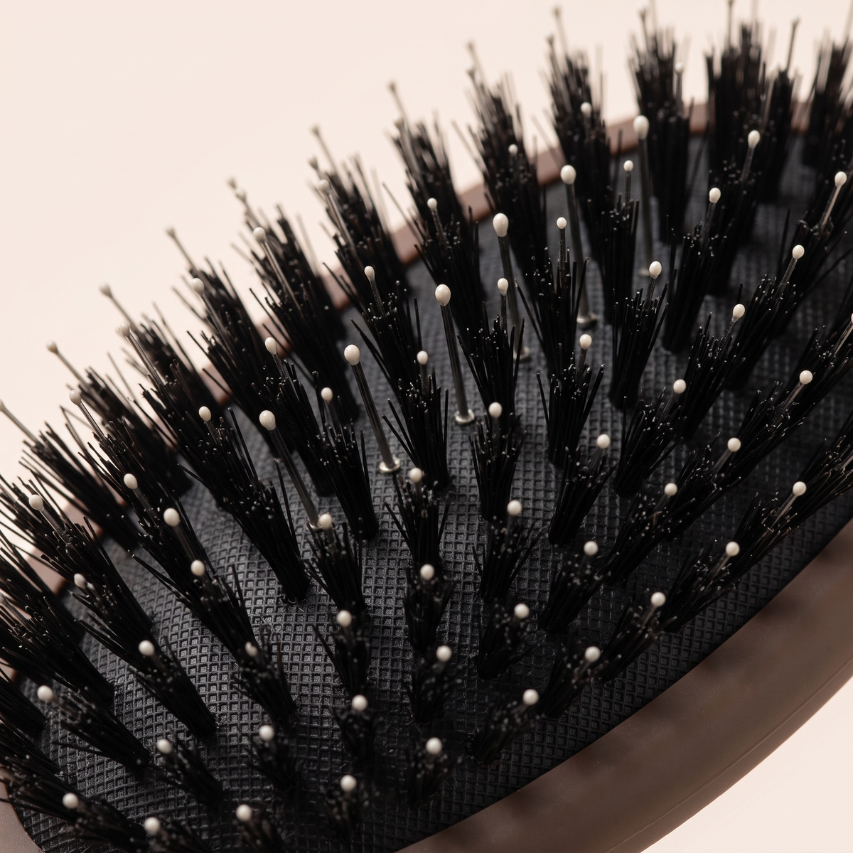 Close-up of the Mane Baby brush cushion pad, showing the dense boar bristle tufts used in both the Original and Mini brushes