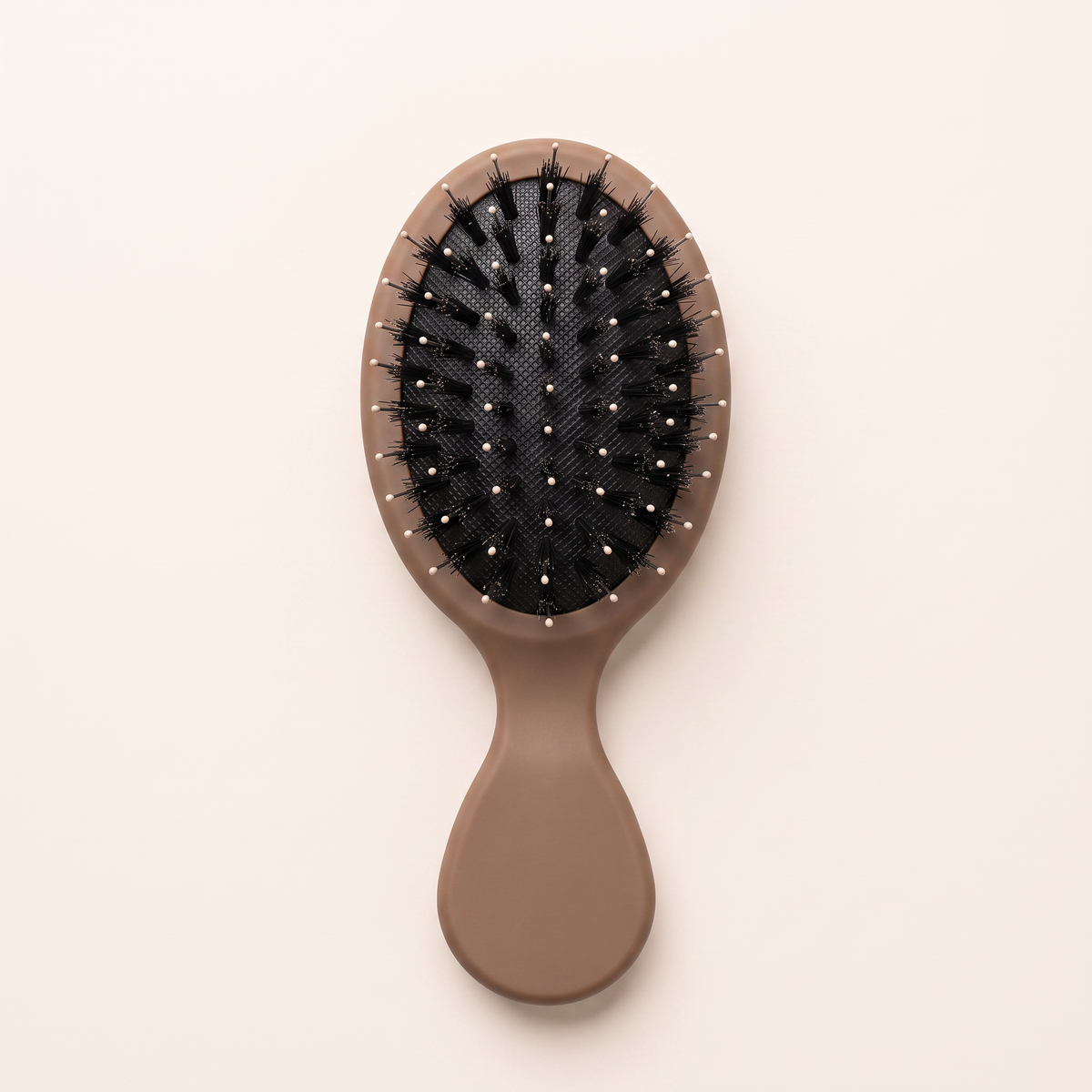 Mane Baby Mini Boar Bristle Brush, bristle side up, showing the black cushion pad with mixed boar bristles