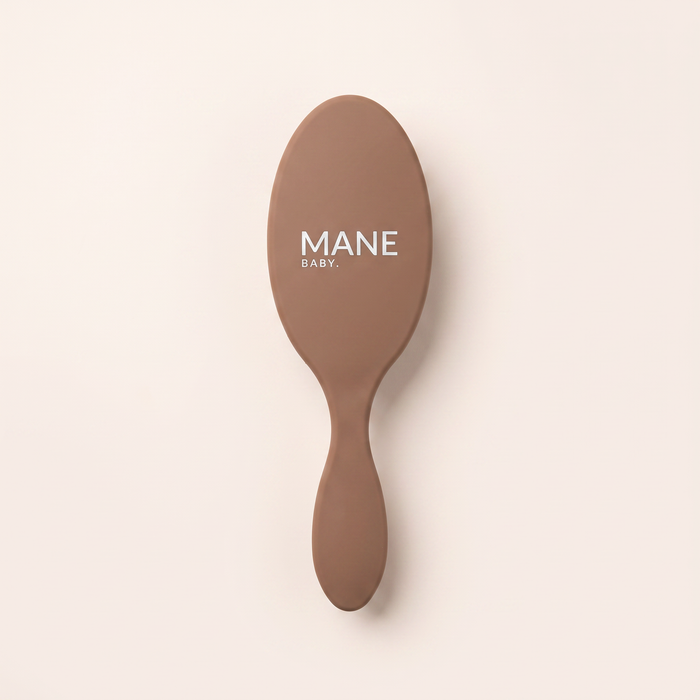 Mane Baby Original Boar Bristle Brush, logo side up, showing the full-size oval paddle and long tapered handle in warm brown
