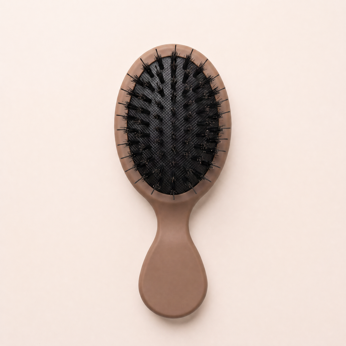Mane Baby Mini Boar Bristle Brush, bristle side up, showing the black cushion pad with mixed boar bristles
