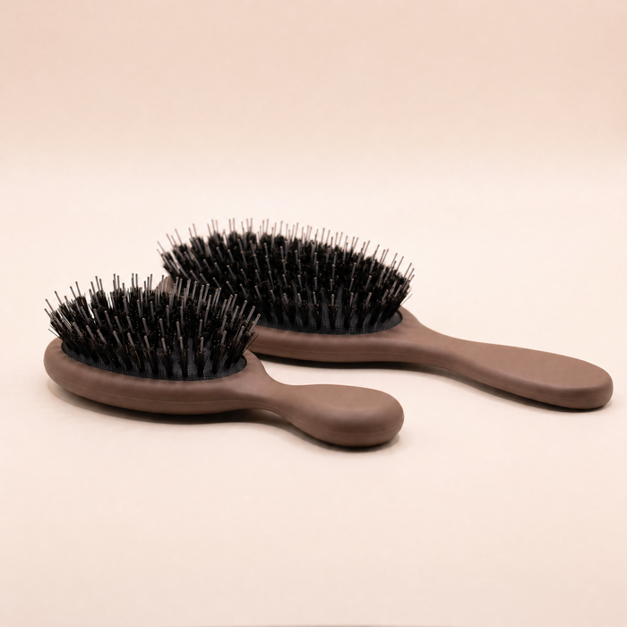 Mane Baby Brush Duo shown side on, revealing the cushioned pad depth and bristle height of both brushes