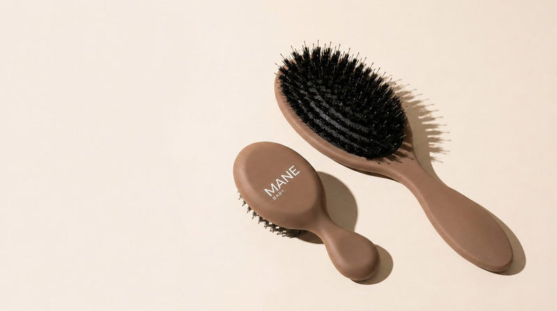 The Mane Baby Original and Mini brushes on cream, bristle pad facing up