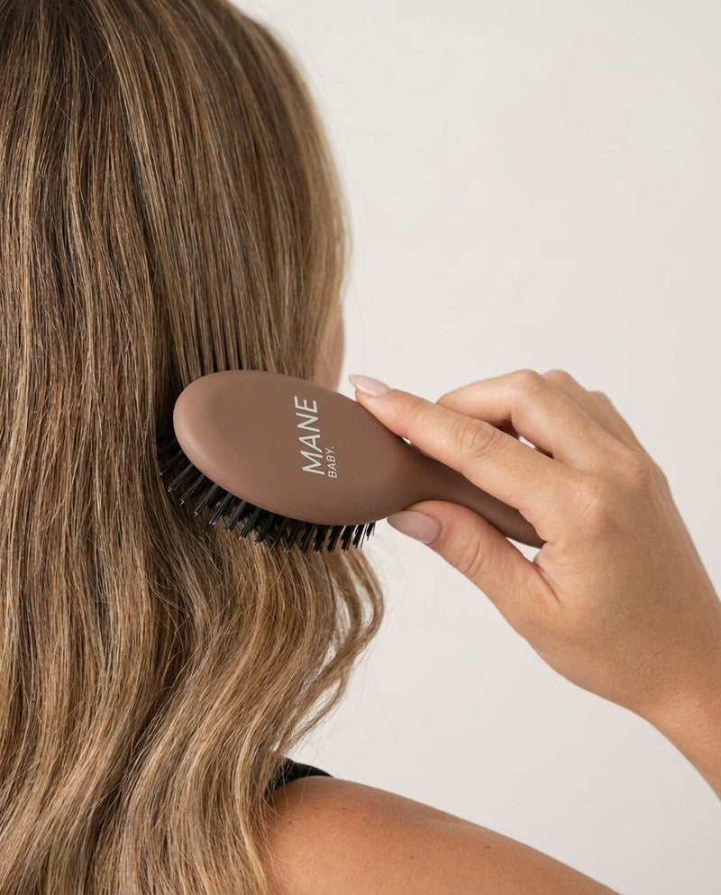The Mane Baby Mini brush in use on long hair